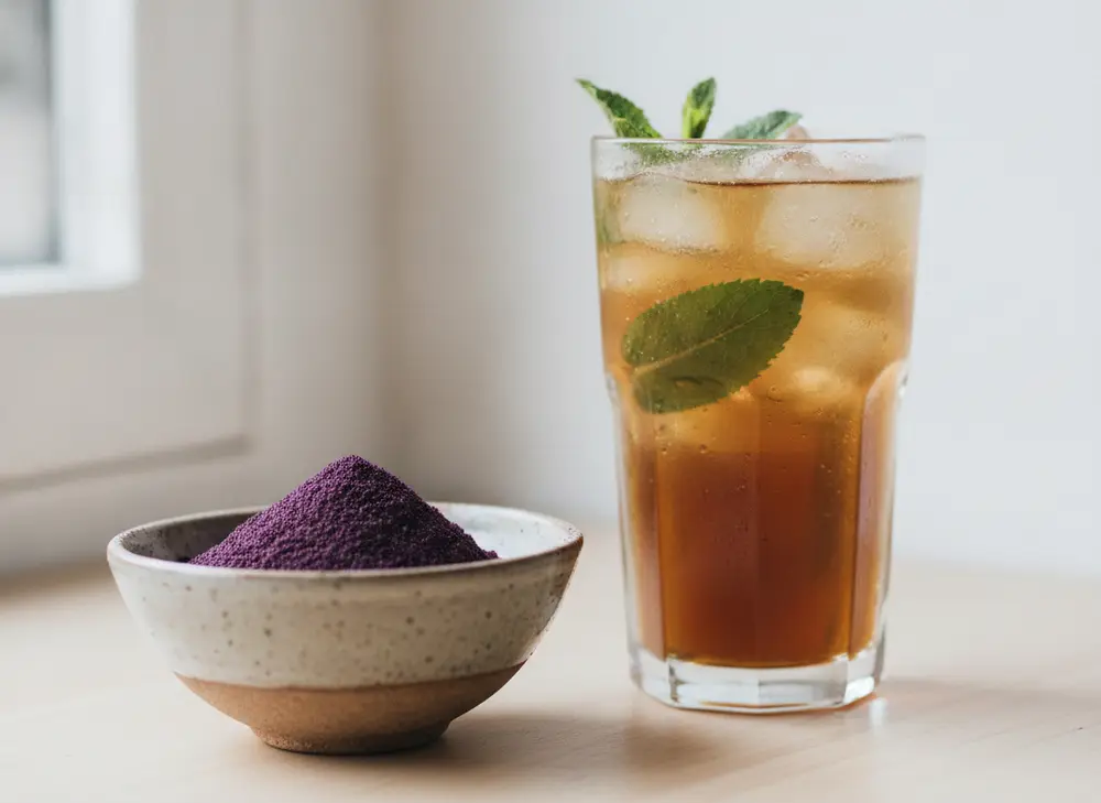 Szklanka mrożonej yerba mate z miętą obok miski proszku acai
