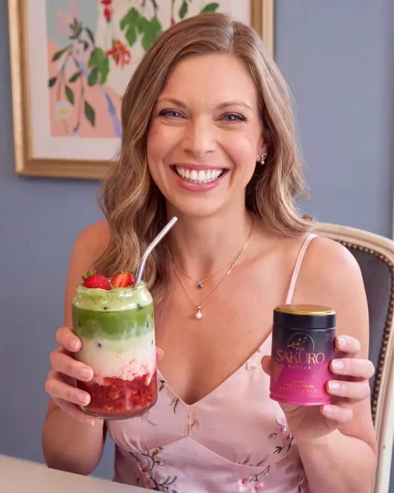 Roześmiana kobieta z truskawkową matcha latte i puszką Sakuro