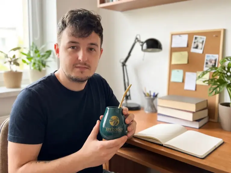 Student z matero Yerbador przy biurku z książkami i notatnikiem w jasnym pokoju