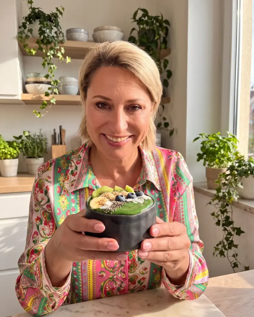 Uśmiechnięta kobieta trzyma zielony bowl w czarnej czarce Fuji